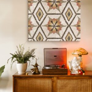 A canvas of an ancient mosaic hangs on the wall above a vintage record plater.