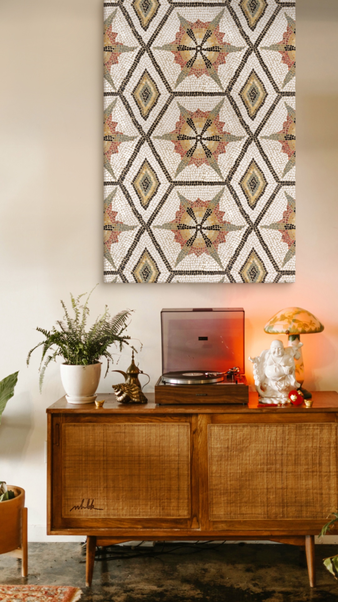 A canvas of an ancient mosaic hangs on the wall above a vintage record plater.